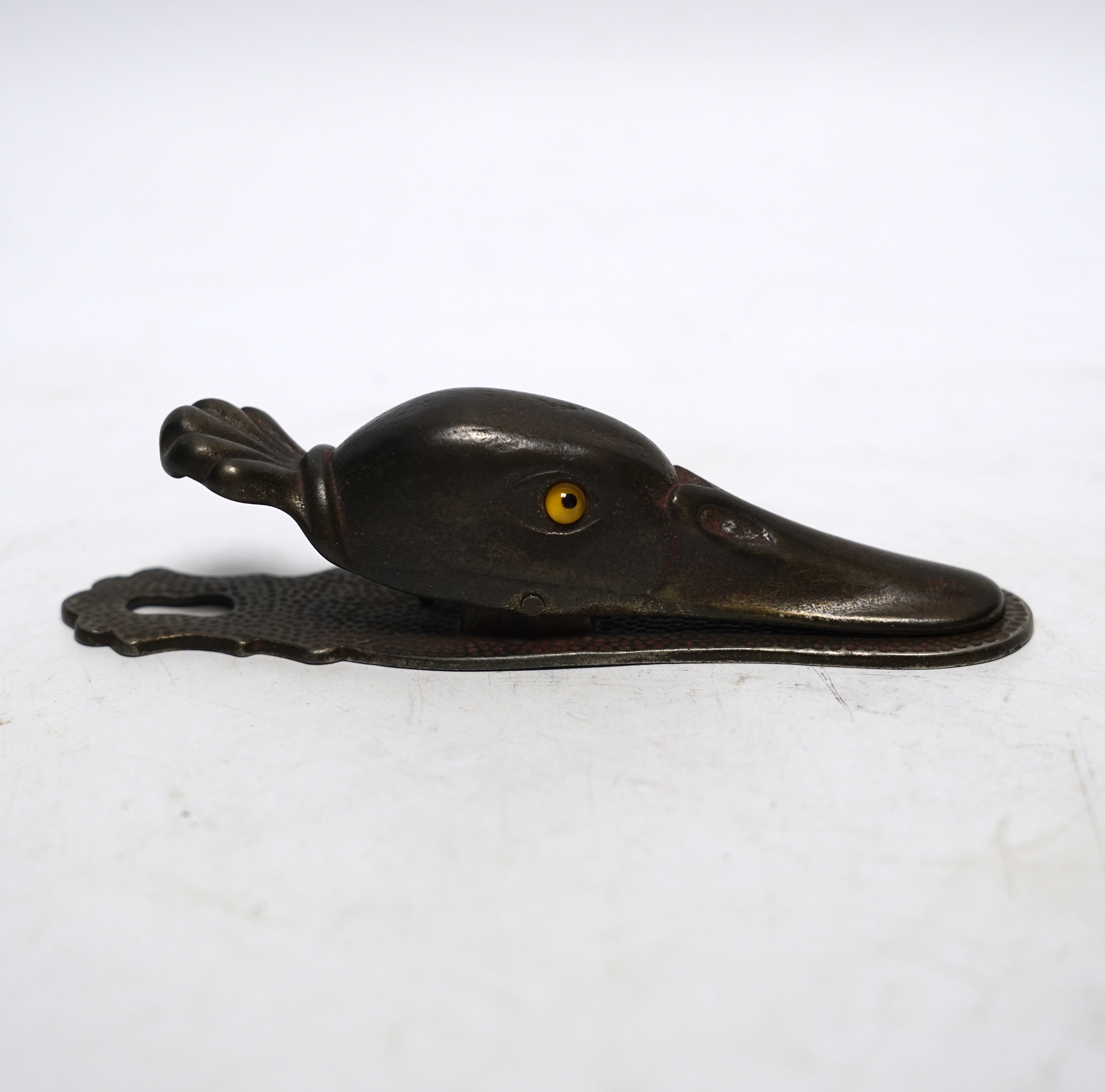 A base metal, glass eyed duck’s head letter clip, with stamp on base: 5180, 13cm long